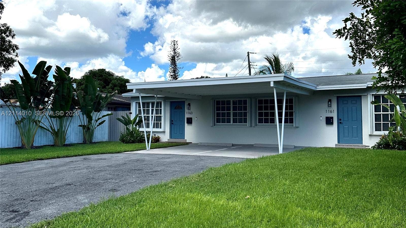 1161-1163 SW 30th Street, Fort Lauderdale, FL 33315 Exterior facade featuring a covered carport, manicured lawn, multi-pane windows, and dual entry doors