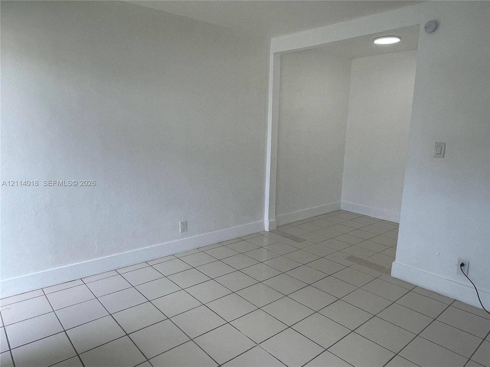 6029 Polk Street, #1B, Hollywood, Hollywood, FL 33024 Neutral-toned interior space featuring ceramic tile flooring, smooth white walls, and recessed ceiling lighting