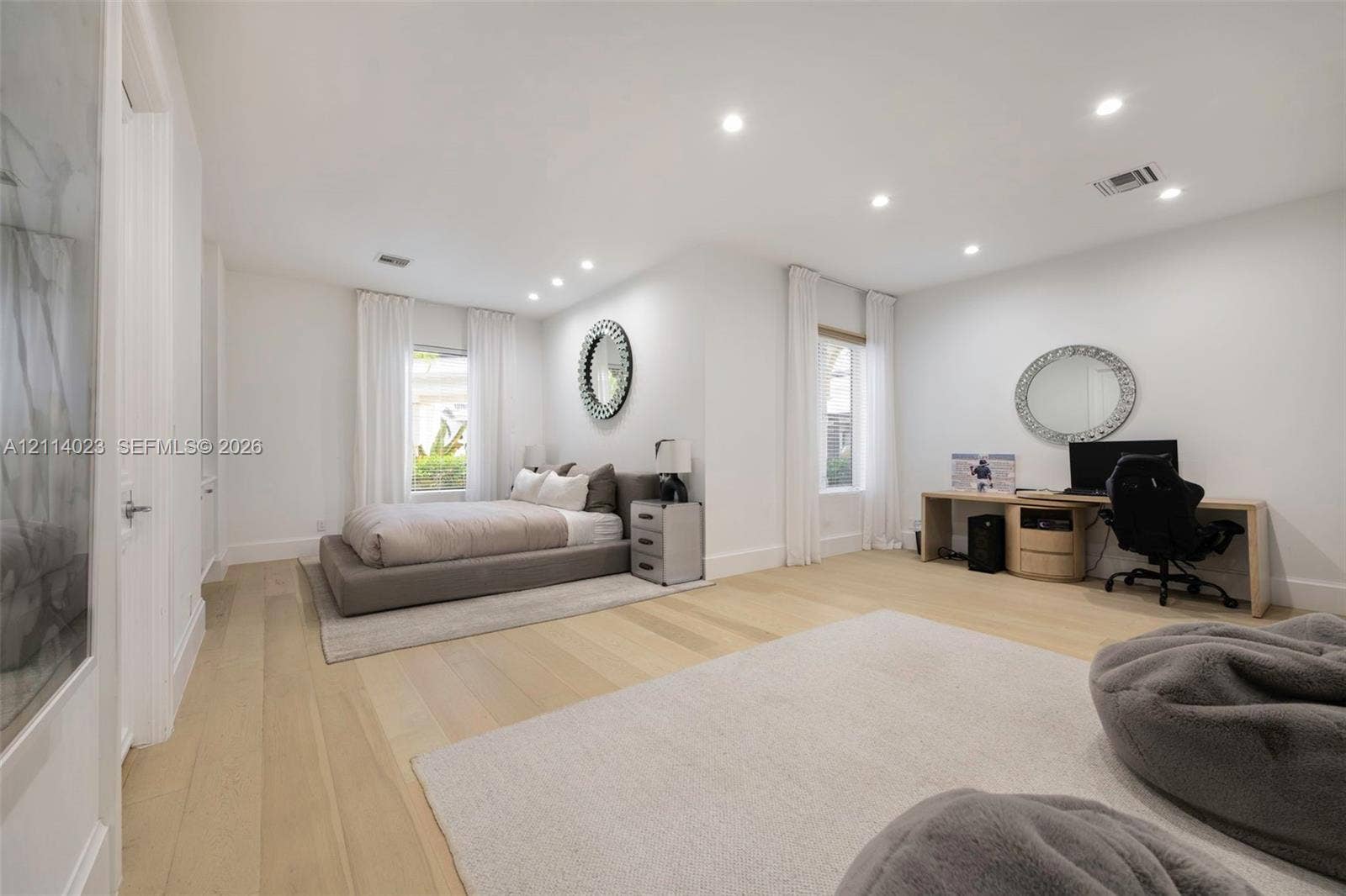 Spacious room featuring wood-finish flooring, recessed lighting, and multiple windows