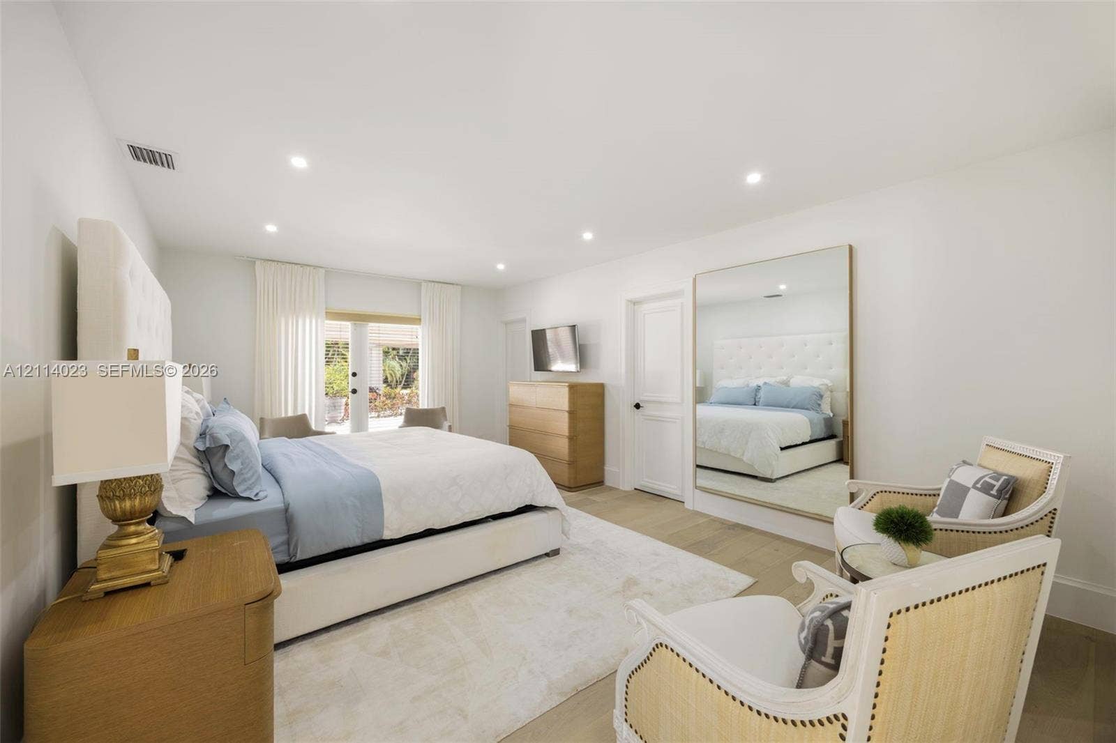 Neutral-toned interior featuring wood-finish flooring, recessed lighting, and a large wall-mounted mirror