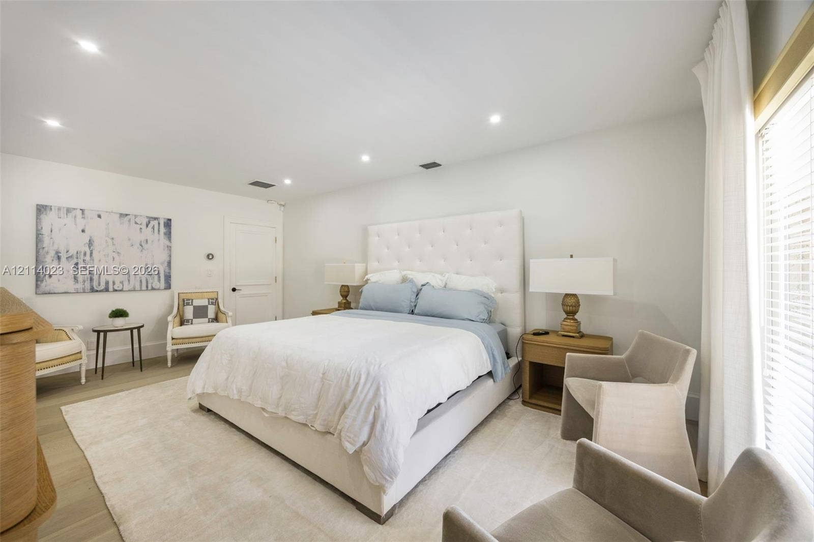Neutral color palette featuring recessed lighting, wood-finish flooring, and large window with horizontal blinds