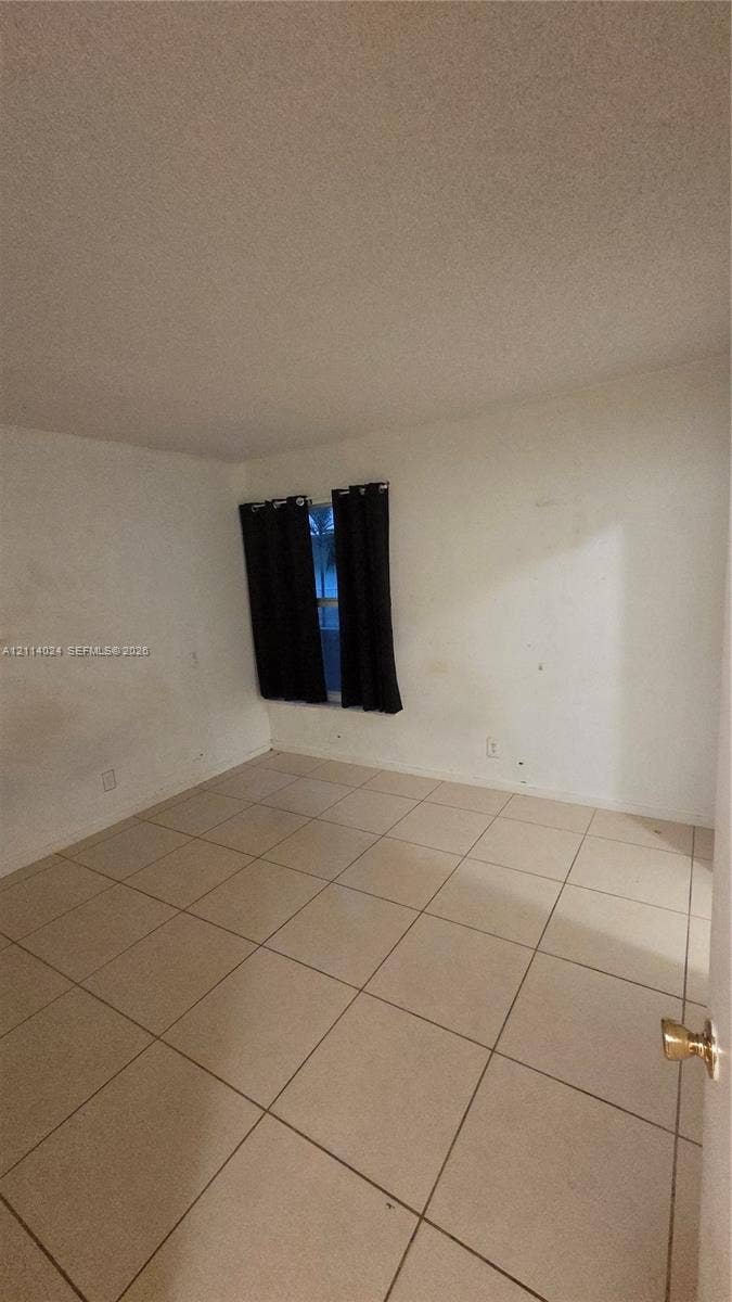 505 S Pine Island Road, #B205, Plantation, FL 33324 Interior space featuring large-format neutral tile flooring and a single window with a dual-panel configuration