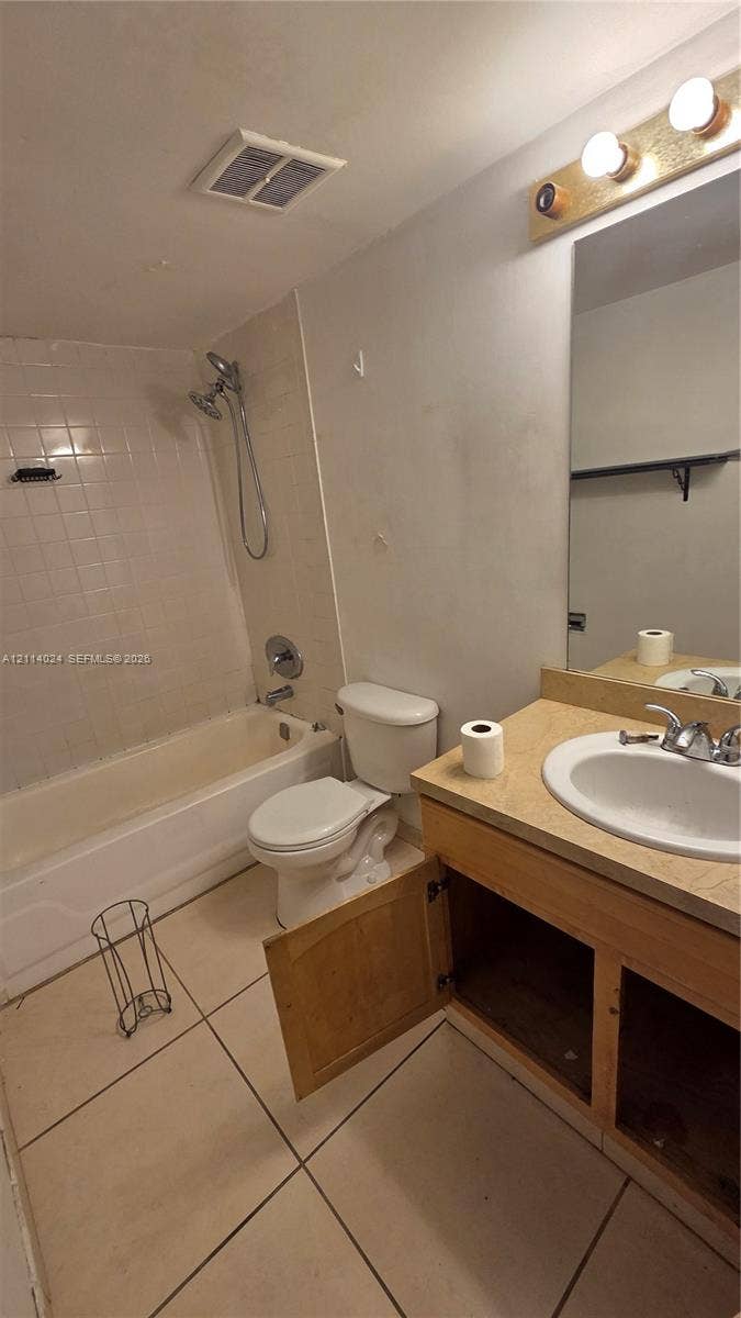 505 S Pine Island Road, #B205, Plantation, FL 33324 Full bathroom featuring large-format floor tile, a soaking tub with integrated shower head, vanity with countertop basin, and wall-mounted vanity lighting