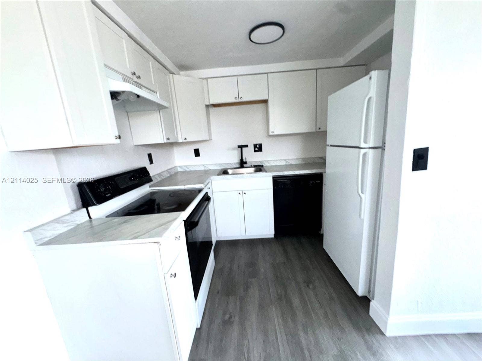 1505 NE 135th Street, #10, North Miami, North Miami, FL 33161 Kitchen featuring white cabinetry, wood-finish flooring, stone-pattern countertops, a stainless steel sink with a matte black faucet, and a black dishwasher