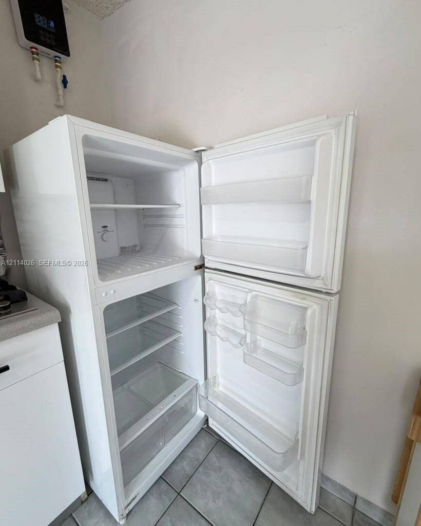 11511 SW 180th Street, #Studio, Miami, Miami, FL 33157 Top-mount white refrigerator featuring adjustable interior shelving, door storage compartments, and crisper drawers