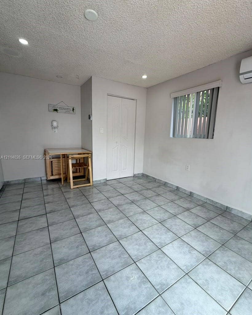 11511 SW 180th Street, #Studio, Miami, Miami, FL 33157 Interior room featuring neutral wall paint, recessed lighting, tile flooring, a wall-mounted ductless mini-split system, and a window with vertical blinds