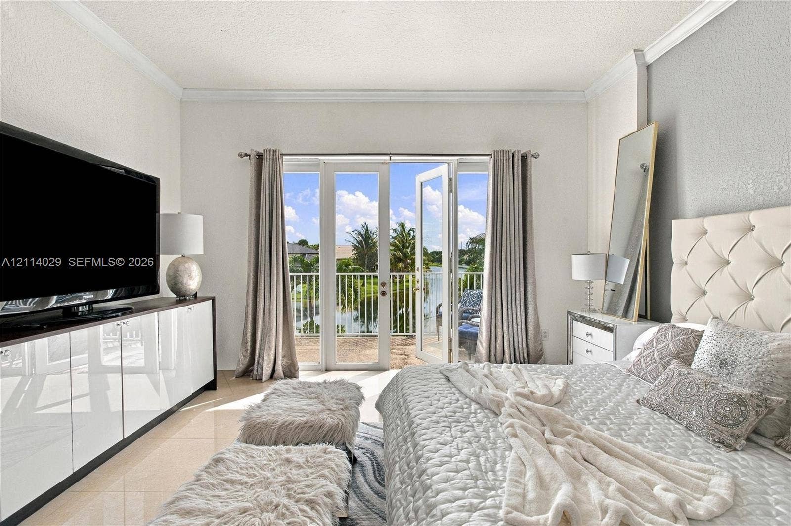 5257 SW 158th Avenue, Miramar, FL 33027 Double glass-paned doors opening to a private balcony, polished tile flooring, crisp crown molding, and built-in glossy white cabinetry