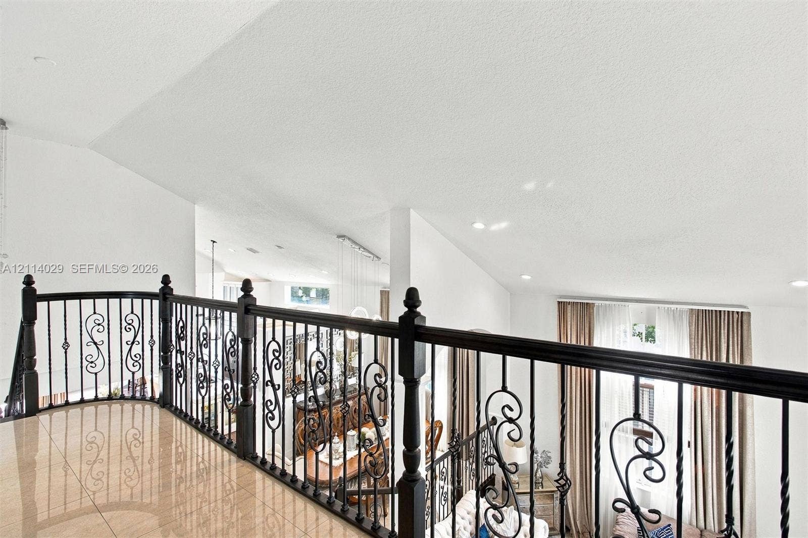 5257 SW 158th Avenue, Miramar, FL 33027 Interior landing featuring polished tile flooring, vaulted ceilings, and ornamental wrought iron balustrading with decorative scrollwork