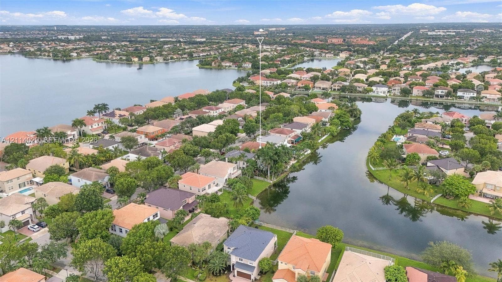 5257 SW 158th Avenue, Miramar, FL 33027 Aerial perspective of a waterfront residential property featuring an expansive canal system, mature landscaping, and multi-story residences