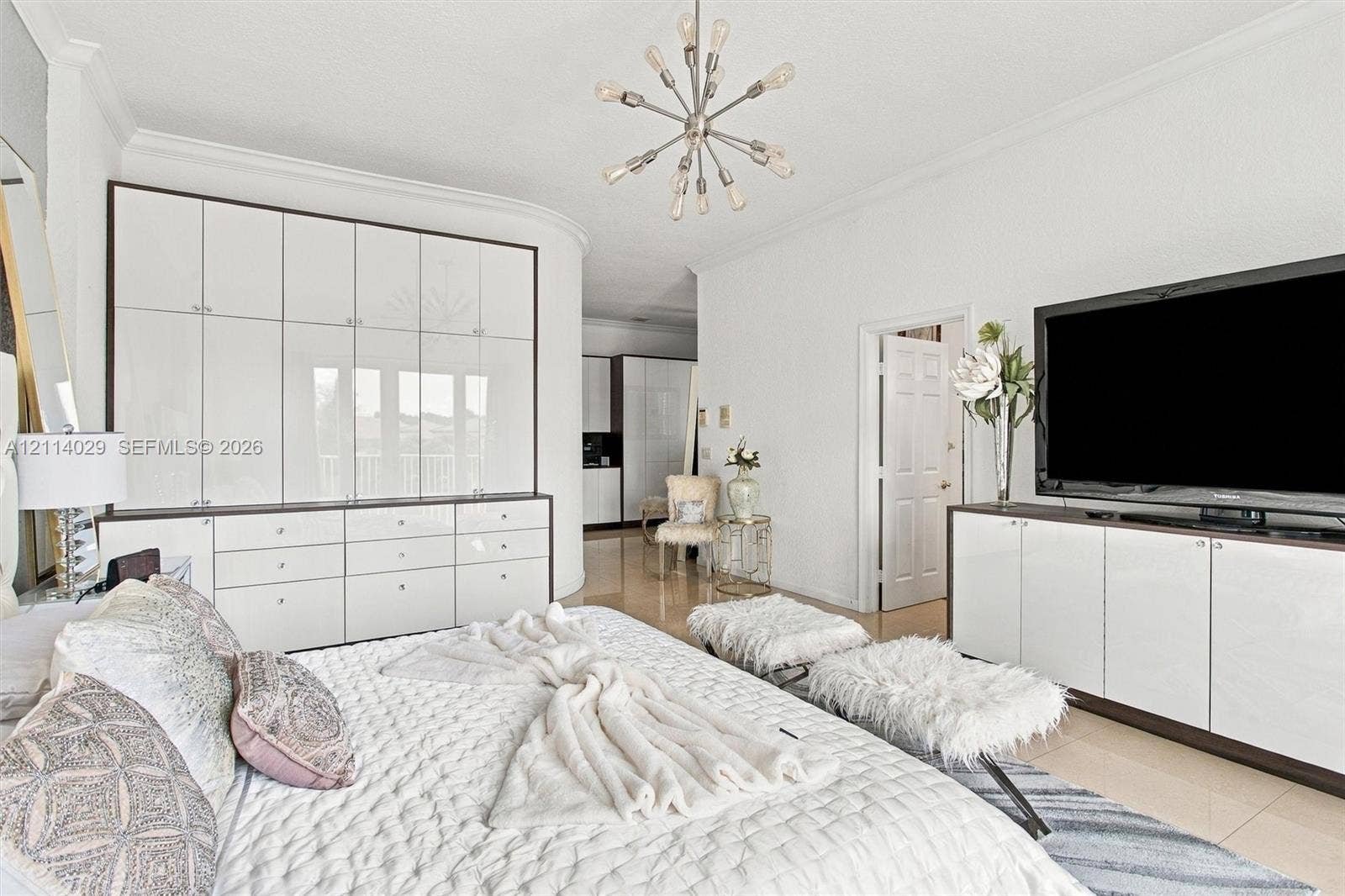5257 SW 158th Avenue, Miramar, FL 33027 Floor-to-ceiling built-in white cabinetry, polished stone flooring, custom integrated media console, and a contemporary multi-arm sputnik chandelier
