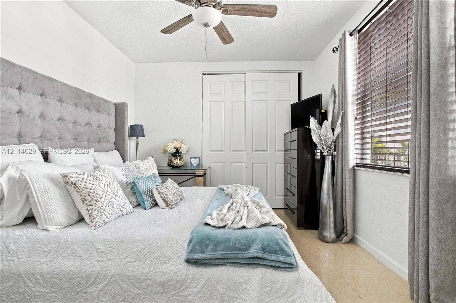5257 SW 158th Avenue, Miramar, FL 33027 Room featuring a ceiling fan with integrated lighting, dual-panel closet doors, and wood-finish flooring