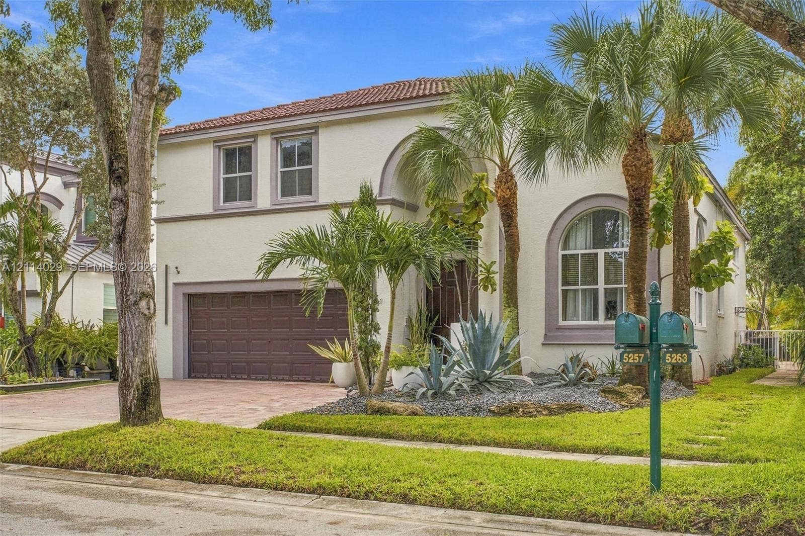 5257 SW 158th Avenue, Miramar, FL 33027 Stucco exterior featuring arched windows, a barrel tile roof, and an attached two-car garage