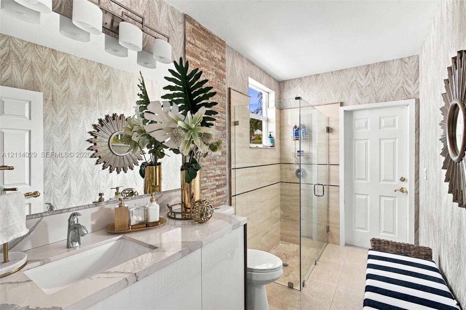 5257 SW 158th Avenue, Miramar, FL 33027 Bathroom featuring a vanity with a white countertop and rectangular undermount sink, glass-enclosed shower with horizontal accent tile, and textured wall treatment