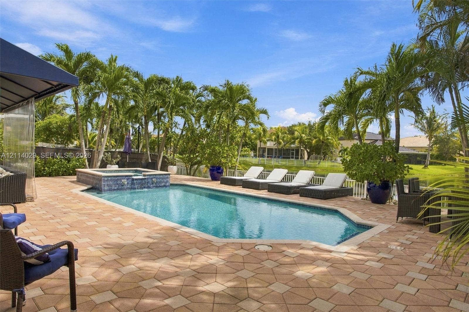 5257 SW 158th Avenue, Miramar, FL 33027 Custom-designed swimming pool with an integrated elevated spa, finished with decorative tile accents and surrounded by expansive paver decking