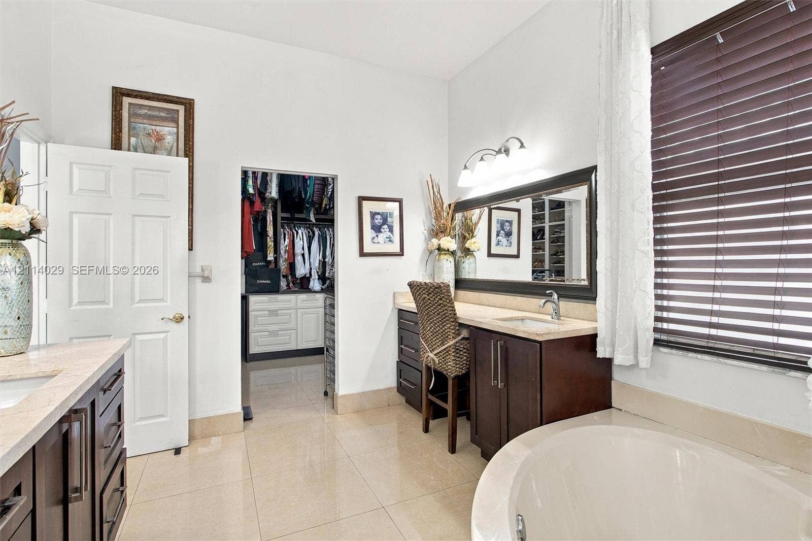 5257 SW 158th Avenue, Miramar, FL 33027 Bathroom featuring dark wood-finish cabinetry, a built-in vanity station, a soaking tub, and a reach-in closet with integrated storage