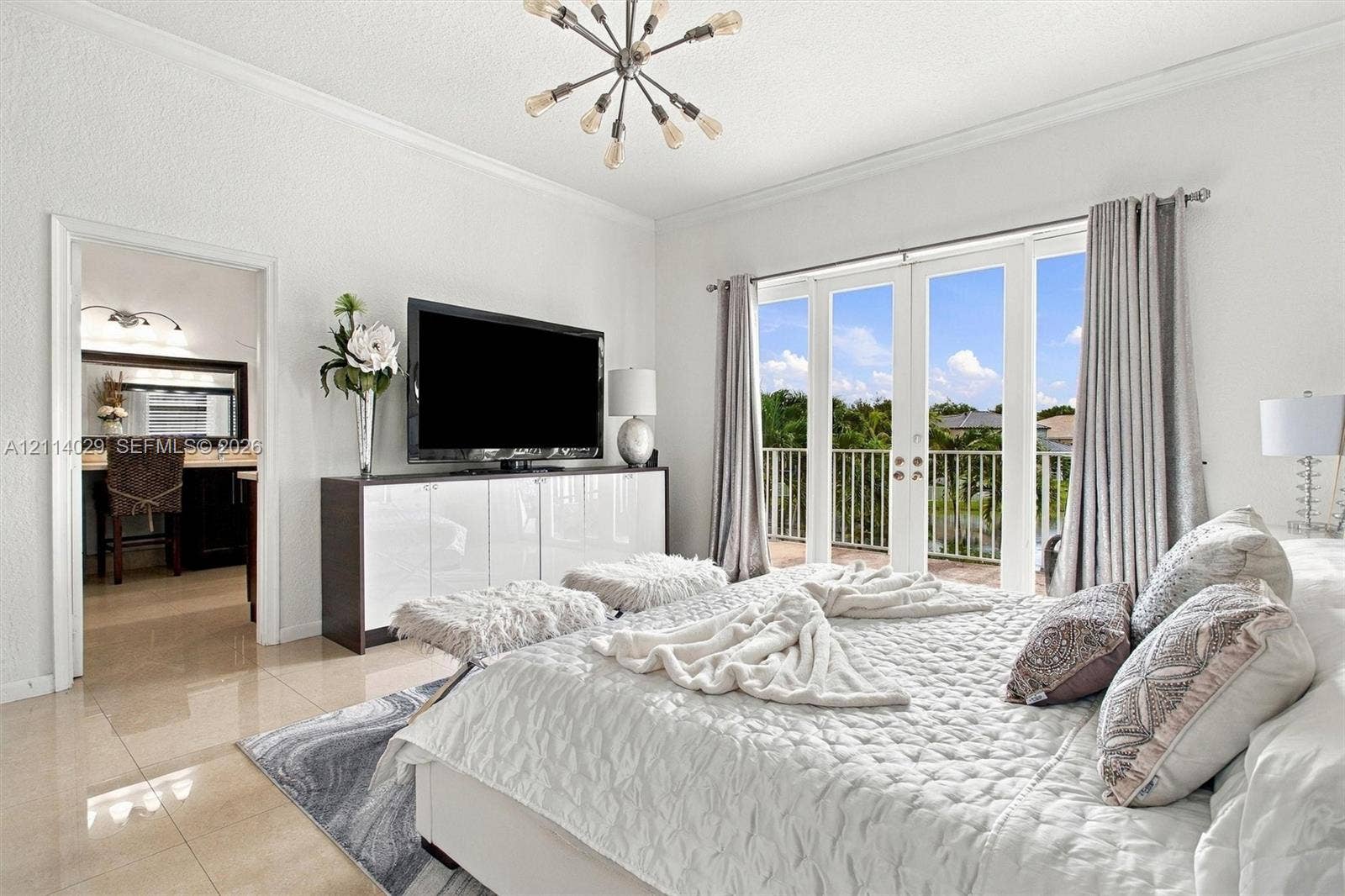 5257 SW 158th Avenue, Miramar, FL 33027 Polished tile flooring, modern sputnik-style chandelier, and double French doors opening to a railed balcony