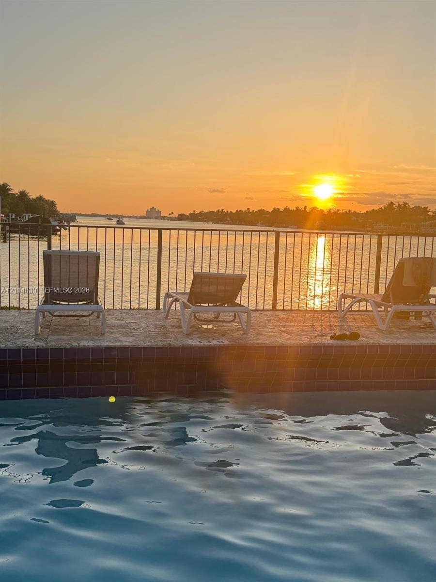8550 Byron Avenue, #2H, Miami Beach, FL 33141 Swimming pool with stone-tiled decking, metal safety fencing, and direct water frontage