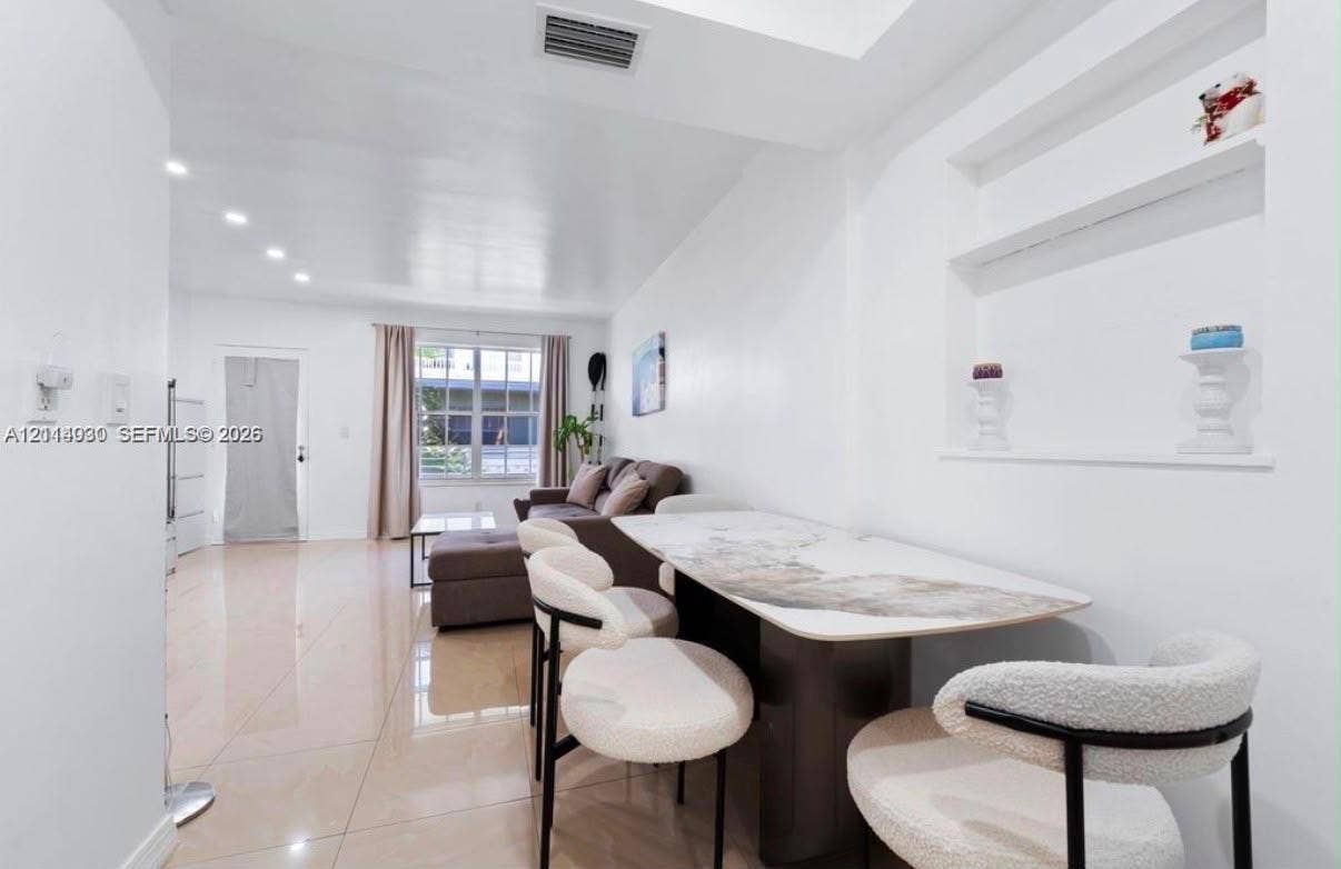 8550 Byron Avenue, #2H, Miami Beach, FL 33141 Open-concept interior featuring high-gloss tile flooring, recessed ceiling lighting, and a built-in recessed wall niche