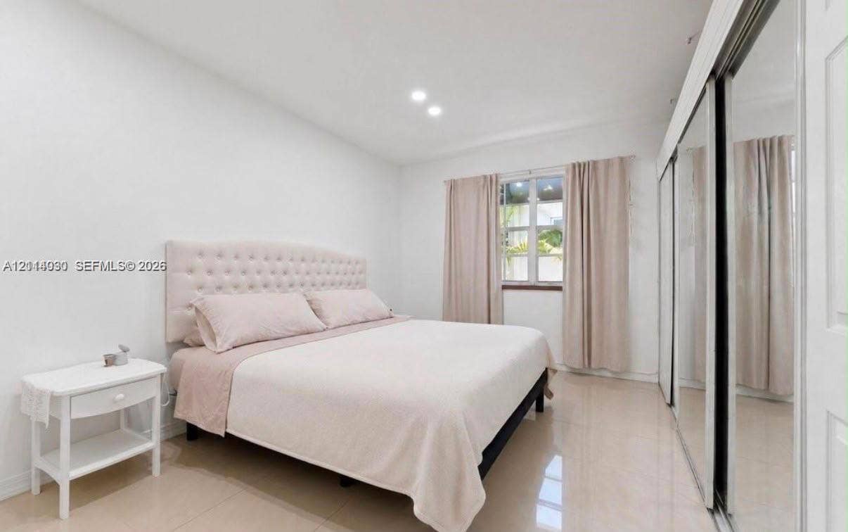 8550 Byron Avenue, #2H, Miami Beach, FL 33141 Bright room featuring neutral-toned tile flooring, recessed ceiling lighting, and floor-to-ceiling mirrored closet doors