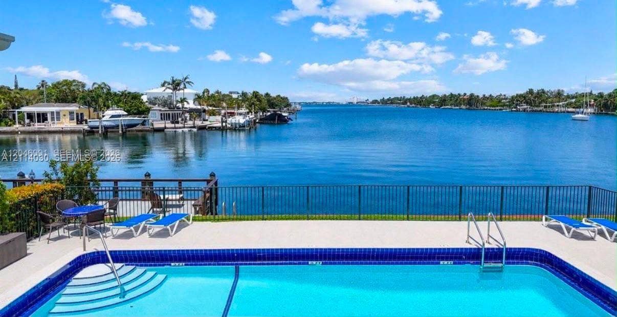 8550 Byron Avenue, #2H, Miami Beach, FL 33141 In-ground swimming pool featuring a tiled waterline, metal safety railing, and concrete pool deck