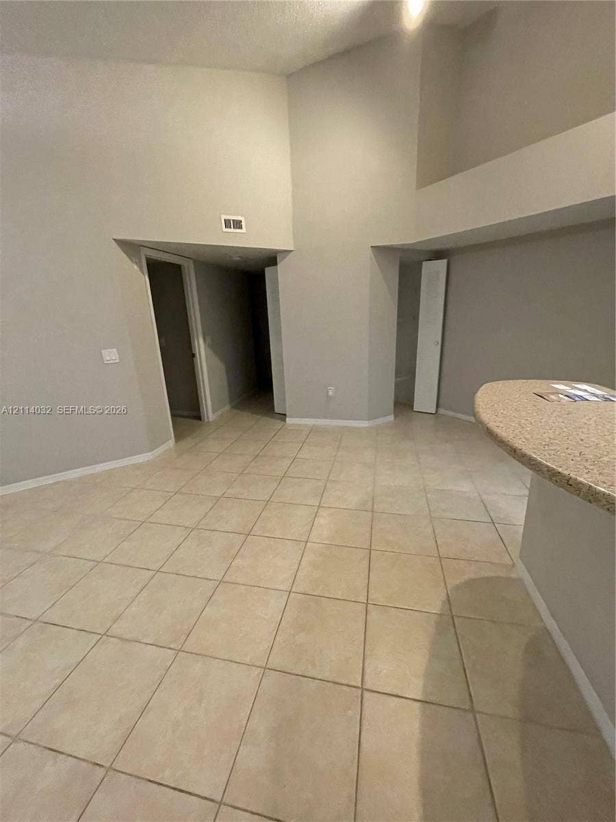 4177 N Haverhill Road, #821, West Palm Beach, West Palm Beach, FL 33417 Vaulted ceiling featuring tile flooring and a built-in stone-finish countertop