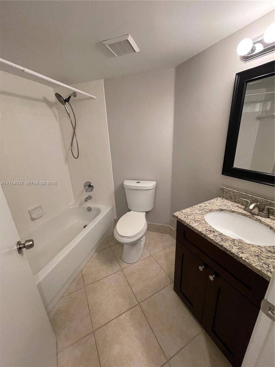 4177 N Haverhill Road, #821, West Palm Beach, West Palm Beach, FL 33417 Bathroom featuring a dark wood vanity with a stone countertop, an integrated porcelain sink, tile flooring, and a shower-tub combination