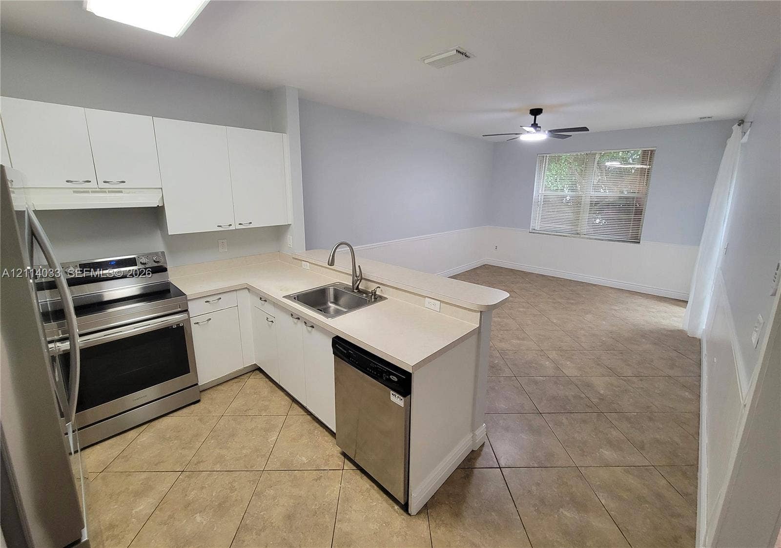 683 NW 88th Drive, Coral Springs, Coral Springs, FL 33071 Kitchen featuring white cabinetry, neutral-toned countertops, stainless steel appliances, a double-basin undermount sink with a gooseneck faucet, and tile flooring