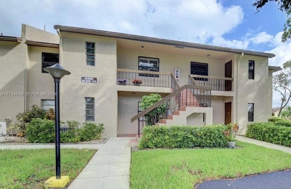 8460 Casa Del Lago, #H, Boca Raton, Boca Raton, FL 33433 Stucco exterior featuring a second-story balcony with metal railings, an open-air staircase, and manicured landscaping