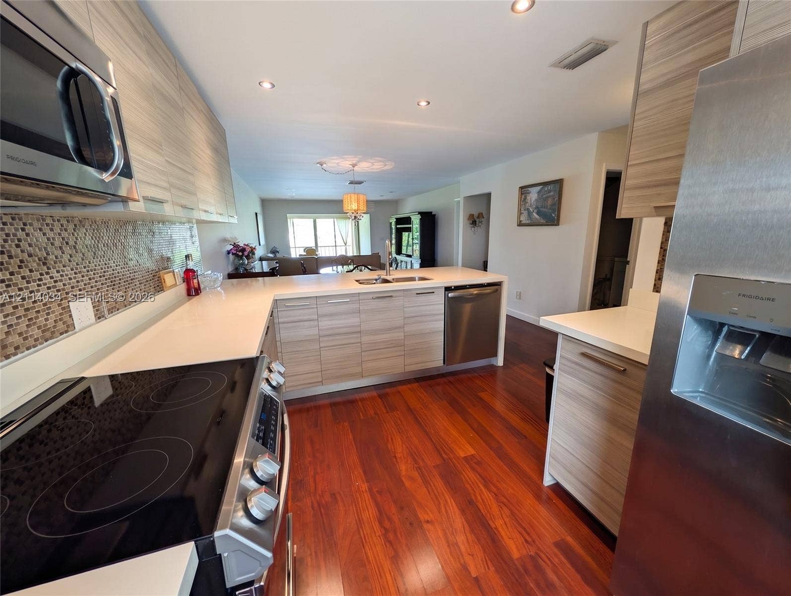 8460 Casa Del Lago, #H, Boca Raton, Boca Raton, FL 33433 Kitchen featuring horizontal-grain wood cabinetry, quartz countertops, stainless steel appliances, mosaic tile backsplash, and wood-finish flooring