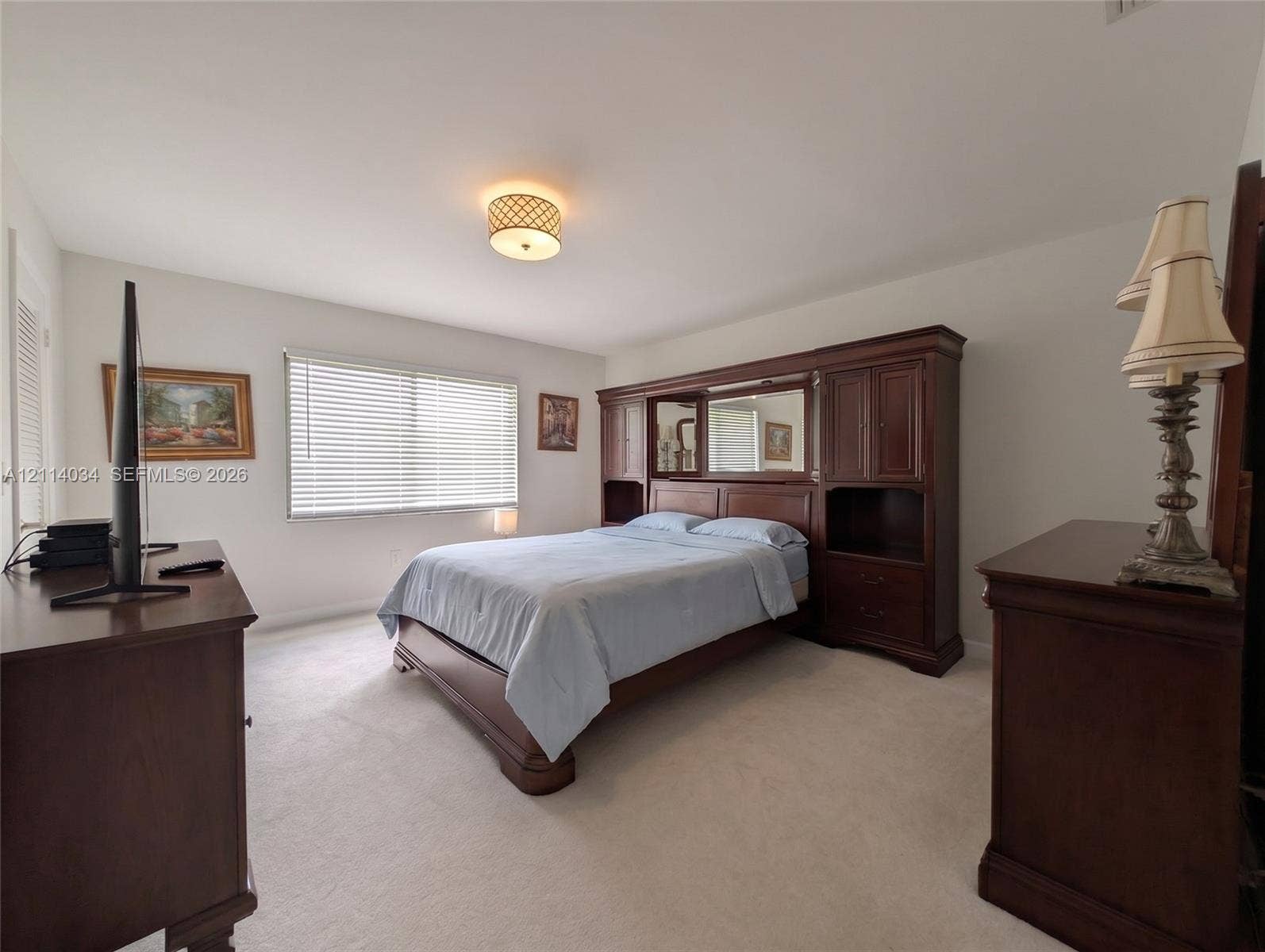 8460 Casa Del Lago, #H, Boca Raton, Boca Raton, FL 33433 Master bedroom featuring neutral carpeting, horizontal window blinds, and a circular drum-style ceiling light fixture