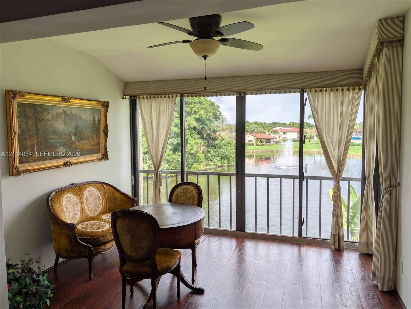 8460 Casa Del Lago, #H, Boca Raton, Boca Raton, FL 33433 Floor-to-ceiling windows featuring a metal railing, rich wood-finish flooring, and a ceiling-mounted light fixture with a multi-blade fan
