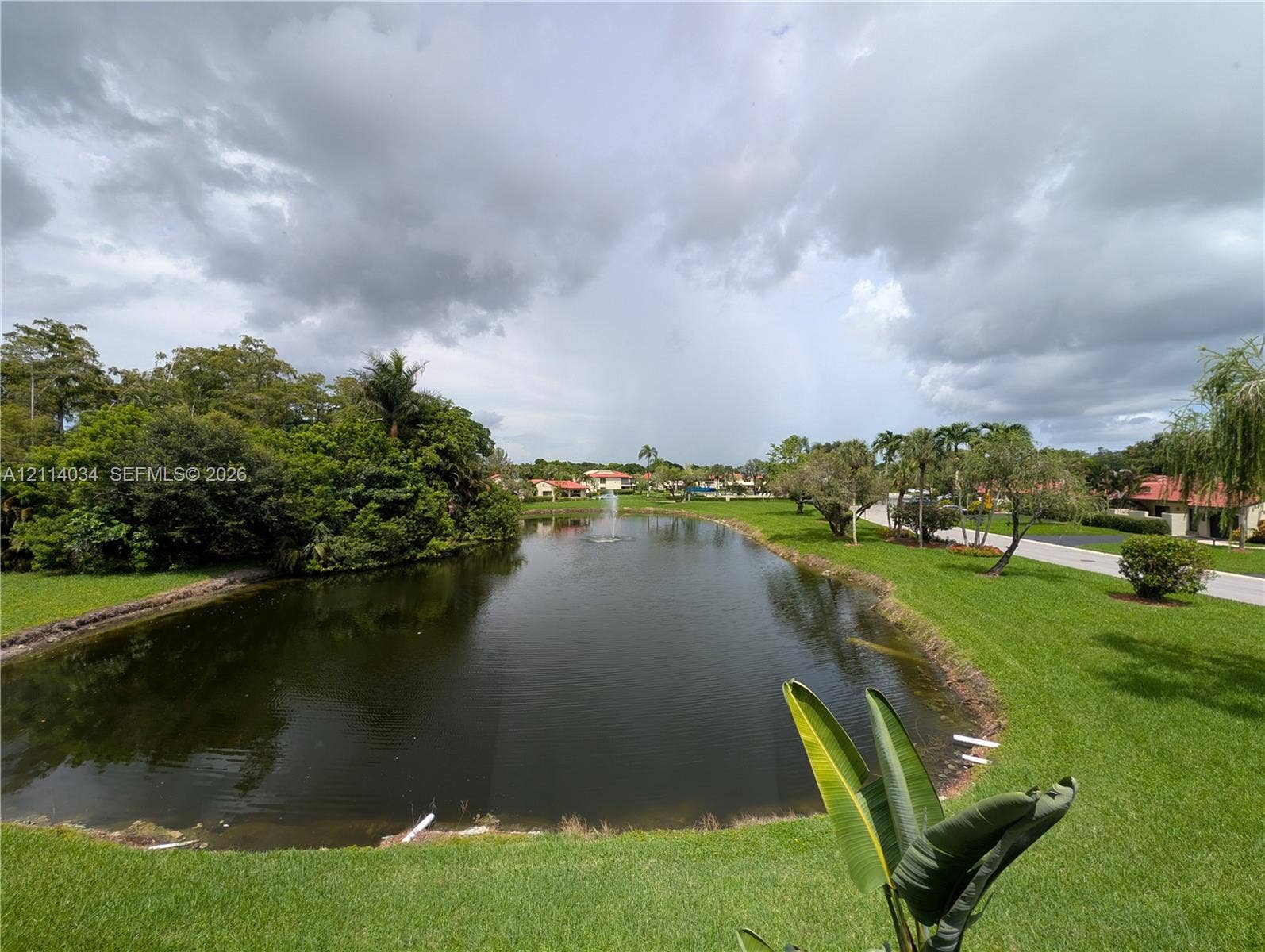 8460 Casa Del Lago, #H, Boca Raton, Boca Raton, FL 33433 Waterfront parcel featuring a central pond, an aerating fountain, mature perimeter landscaping, and expansive green space