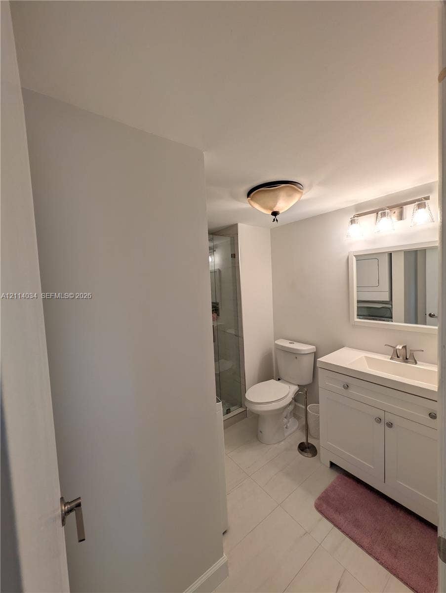 8460 Casa Del Lago, #H, Boca Raton, Boca Raton, FL 33433 Bathroom featuring a white vanity cabinet with a rectangular basin, ceramic tile flooring, a glass-enclosed shower, and a wall-mounted multi-light fixture