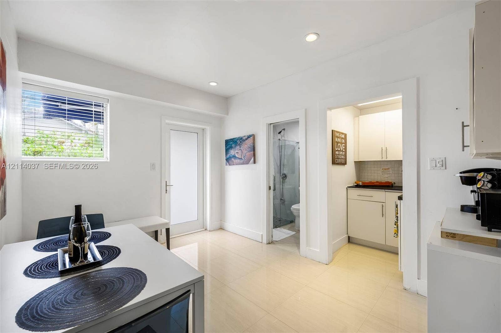8436 SW 143rd Avenue, Miami, FL 33183 Neutral-toned tile flooring, recessed ceiling lighting, glass-panel entry door, and white cabinetry with a dark stone-surface countertop