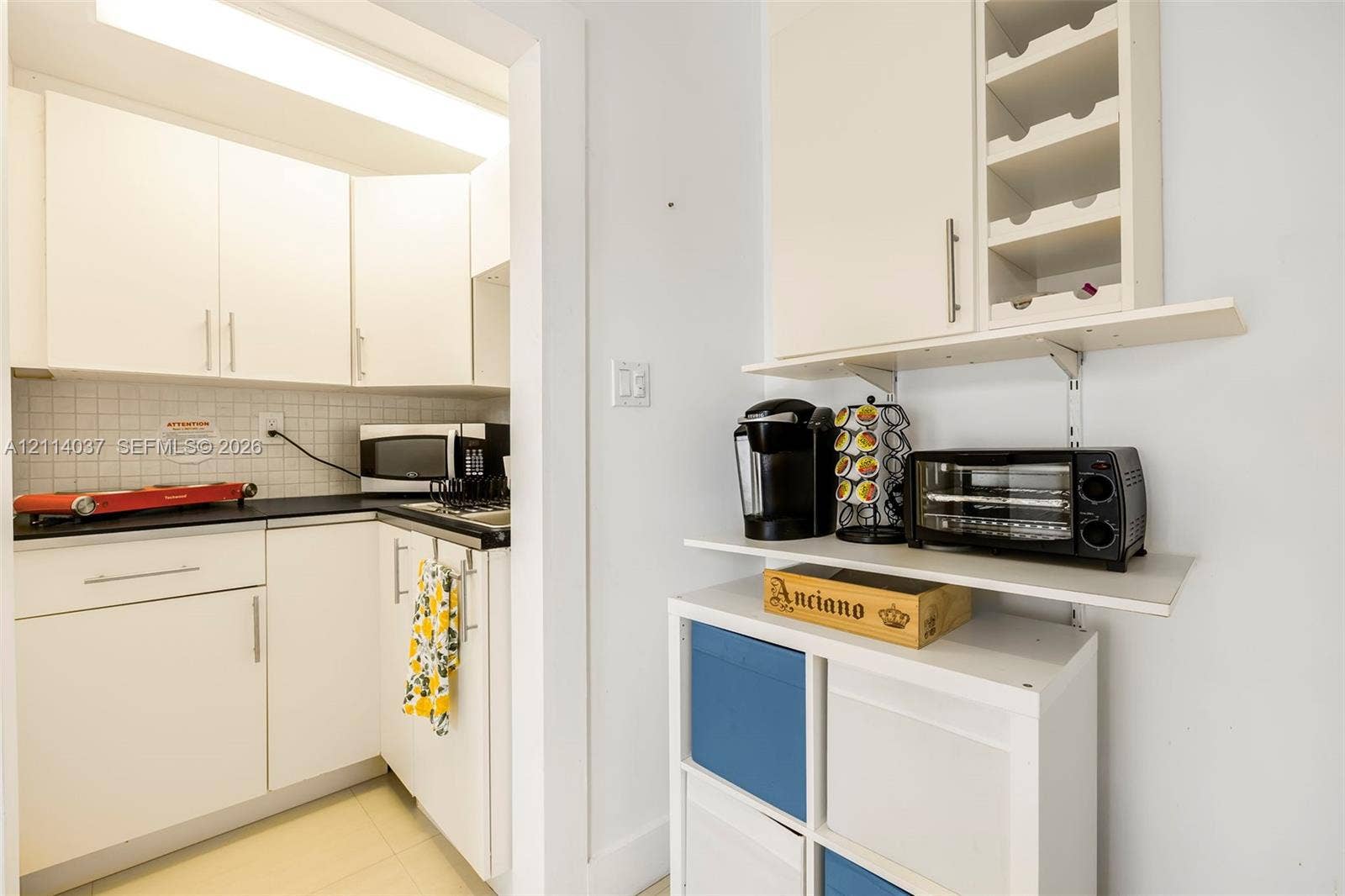 8436 SW 143rd Avenue, Miami, FL 33183 Kitchen featuring white cabinetry, dark countertops, square tile backsplash, and built-in wine storage
