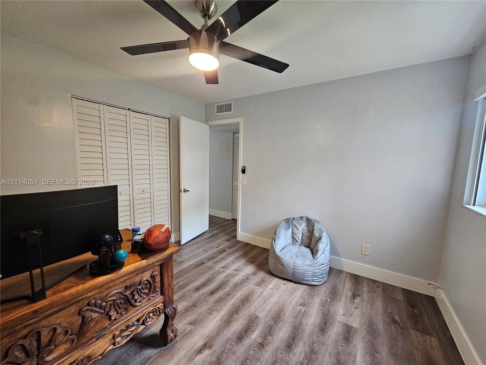 2431 SW 82nd Avenue, #102, Davie, FL 33324 Wood-finish flooring, ceiling fan with integrated lighting, and louvered-door closet
