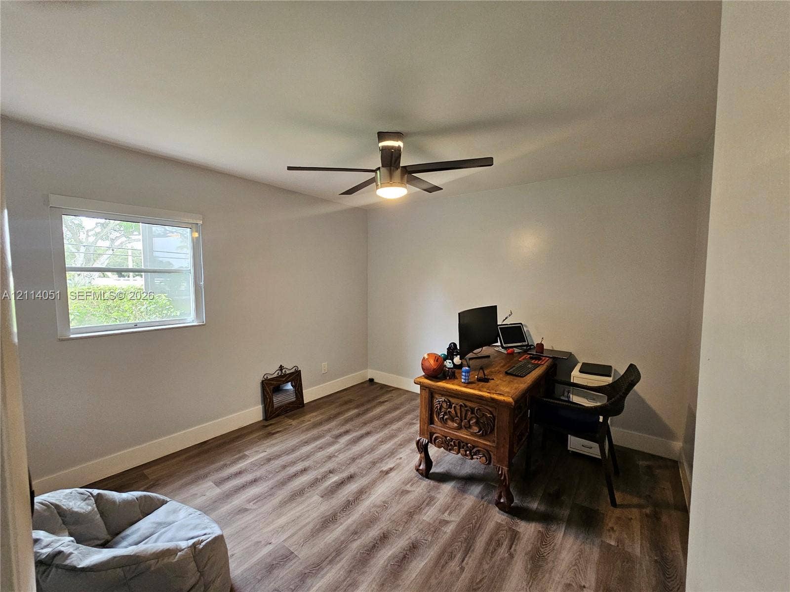 2431 SW 82nd Avenue, #102, Davie, FL 33324 Interior room featuring wood-finish flooring, a neutral wall color palette, and a multi-blade ceiling fan with an integrated light fixture