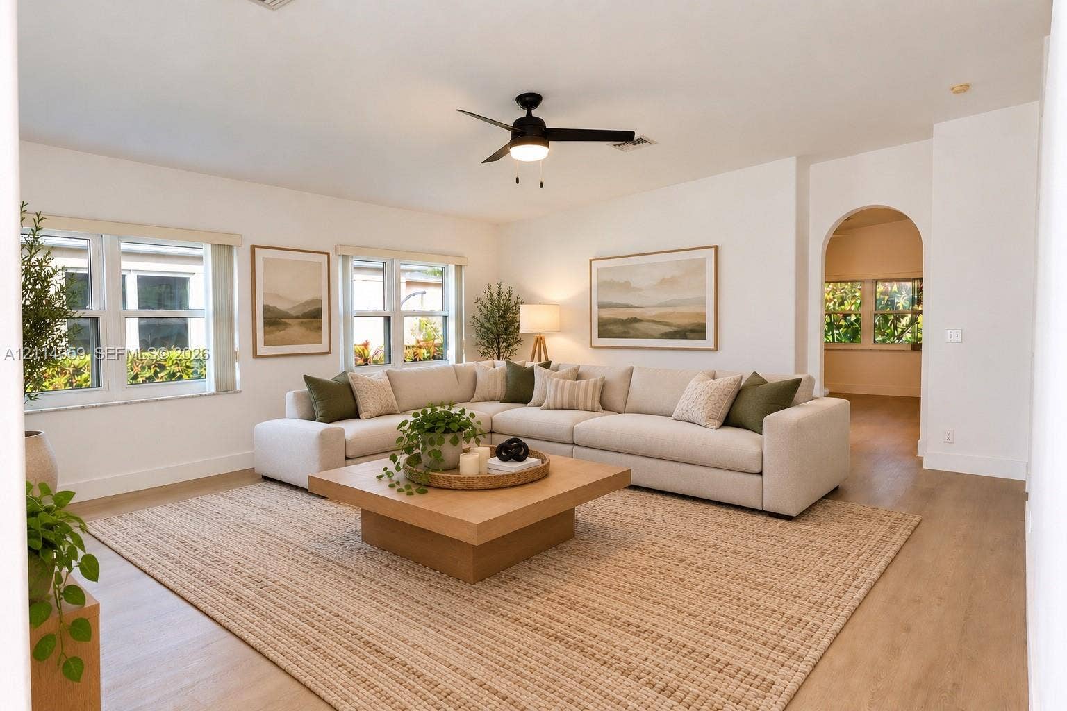 8023 N Tranquility Lake Drive, Delray Beach, FL 33446 Spacious living area featuring wood-finish flooring, recessed lighting, a modern ceiling fan, and an architectural arched entryway