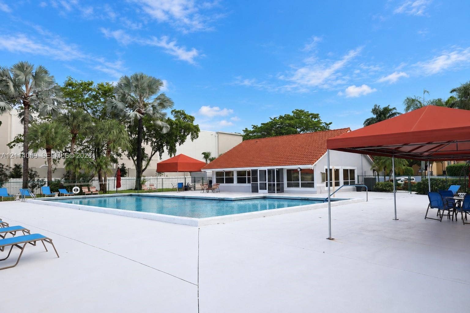 8023 N Tranquility Lake Drive, Delray Beach, FL 33446 Swimming pool with a paved deck, terracotta-tiled roof structure, and perimeter landscaping