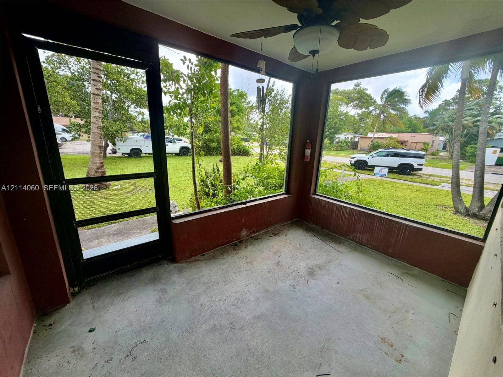 2325 Fillmore Street, #1, Hollywood, Hollywood, FL 33020 Enclosed patio featuring floor-to-ceiling windows, a screen door, and a ceiling-mounted light fixture with a fan