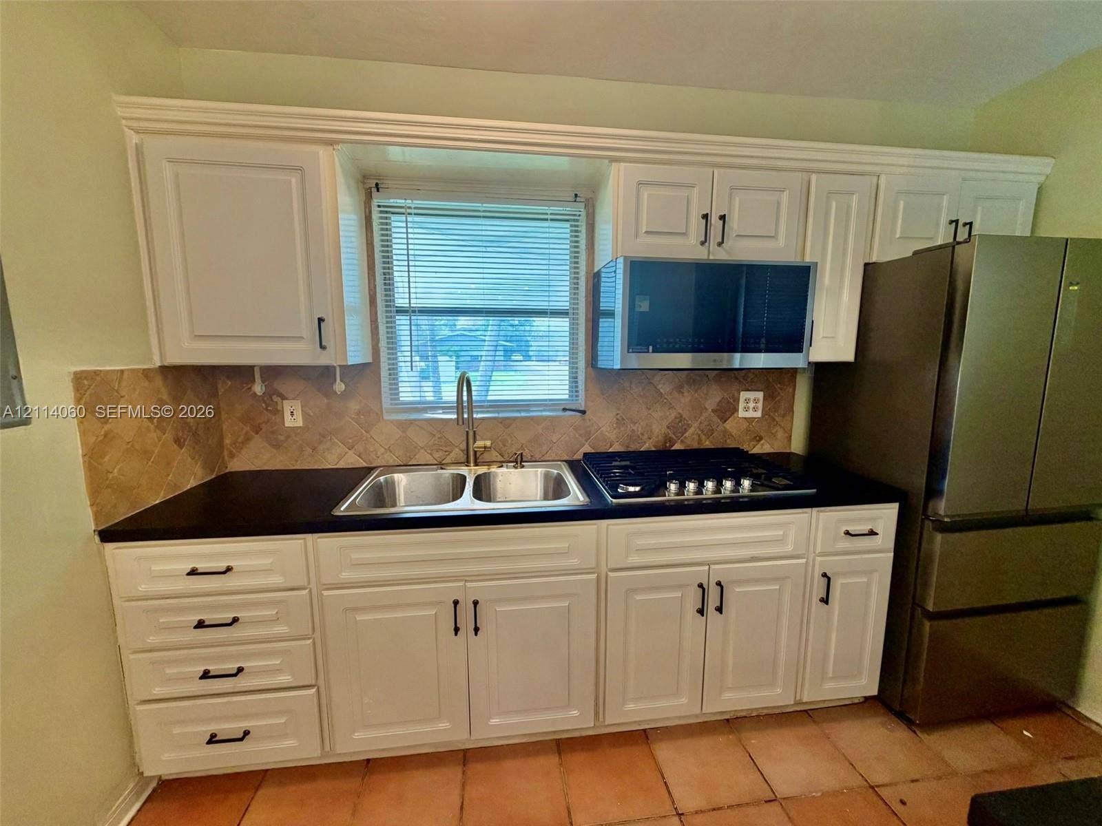 2325 Fillmore Street, #1, Hollywood, Hollywood, FL 33020 Kitchen featuring white shaker-style cabinetry, dark stone countertops, a dual-basin stainless steel sink, a built-in stainless steel gas cooktop, and a stone tile backsplash