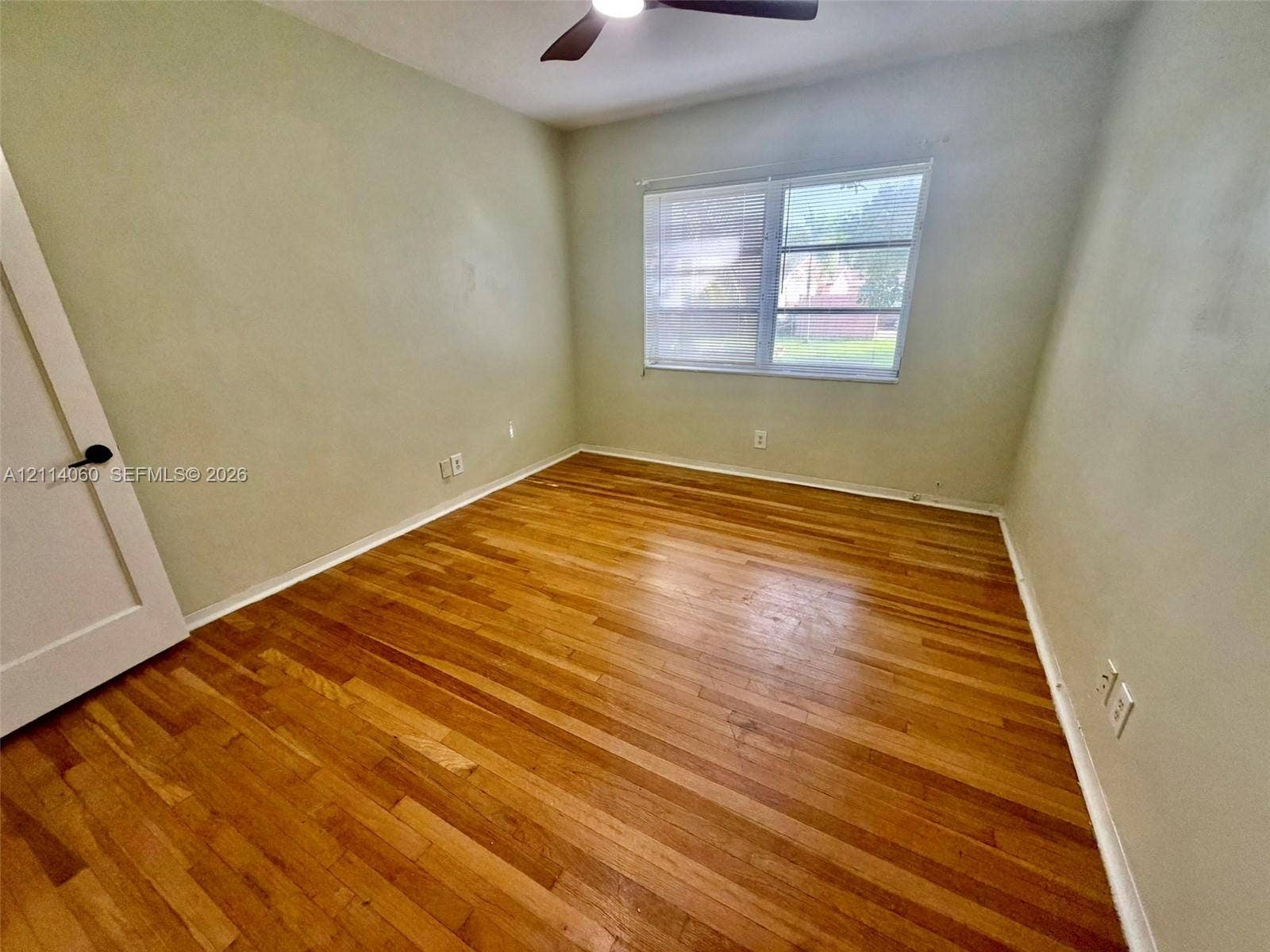 2325 Fillmore Street, #1, Hollywood, Hollywood, FL 33020 Interior space featuring wood-finish flooring, a multi-pane window, and an attached ceiling fan