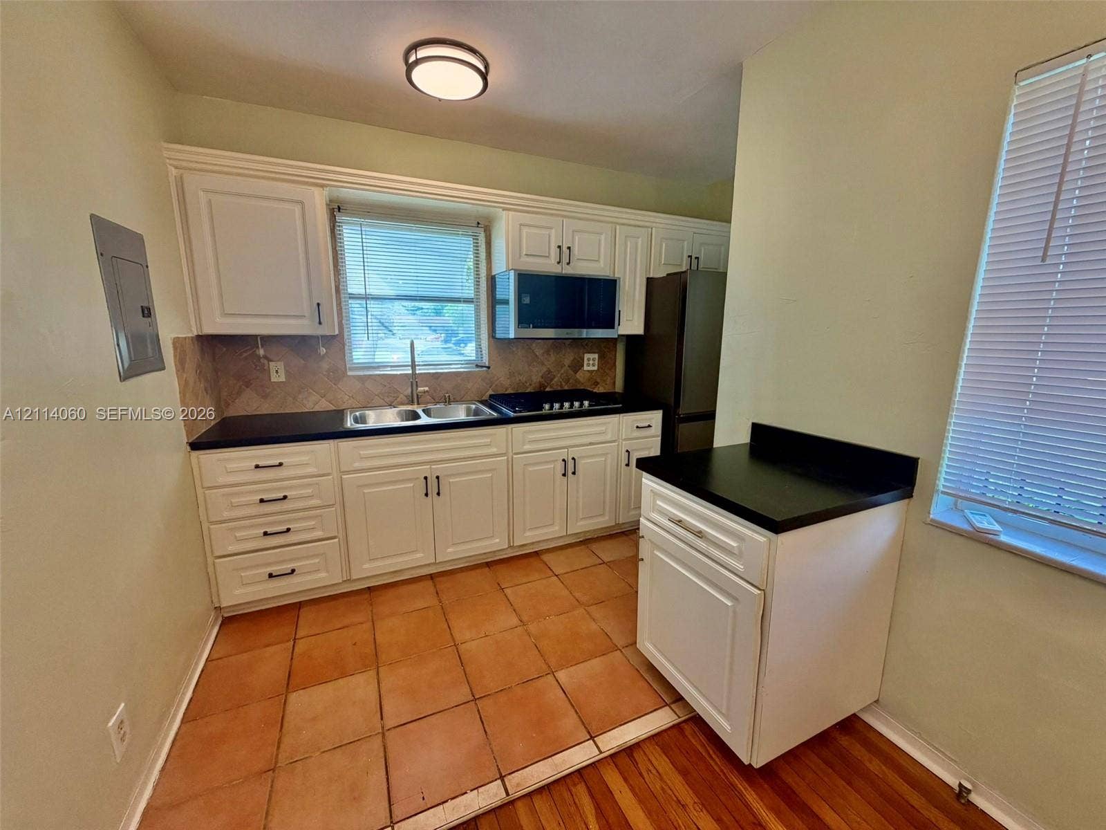 2325 Fillmore Street, #1, Hollywood, Hollywood, FL 33020 Kitchen featuring white cabinetry, dark stone-finish countertops, ceramic tile backsplash, built-in microwave, and terracotta-style floor tiles