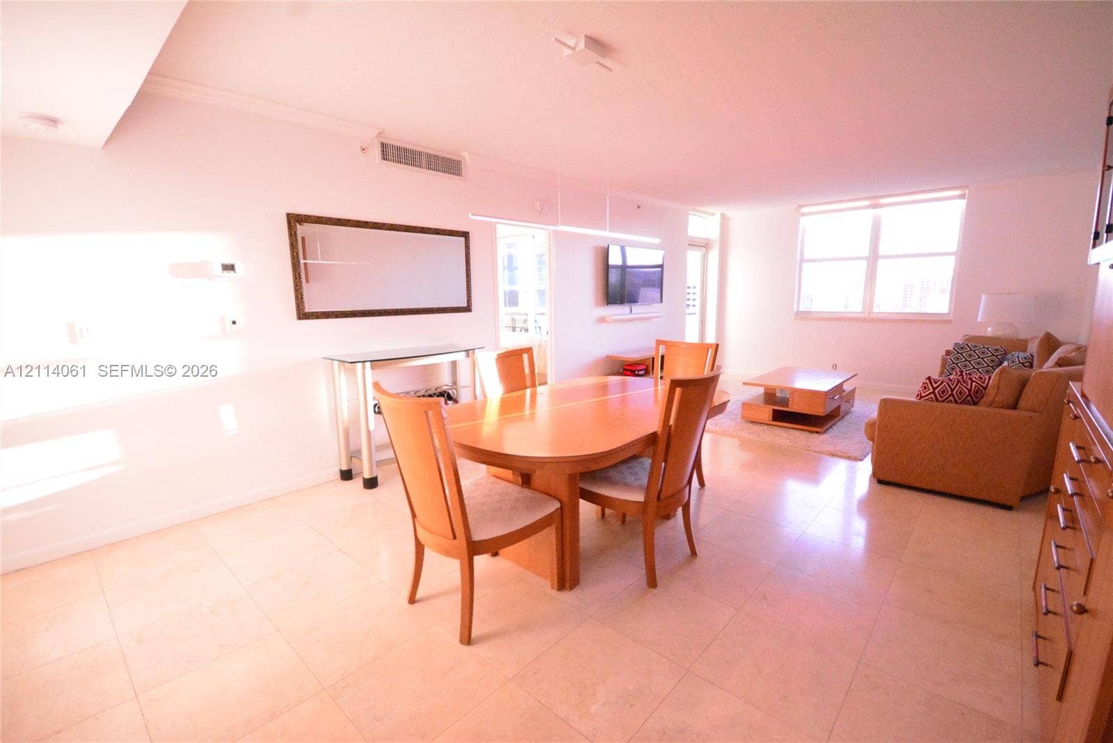 3001 S Ocean Drive, #727, Hollywood, FL 33019 Open-concept area featuring neutral stone flooring, a minimalist linear pendant light, and large windows
