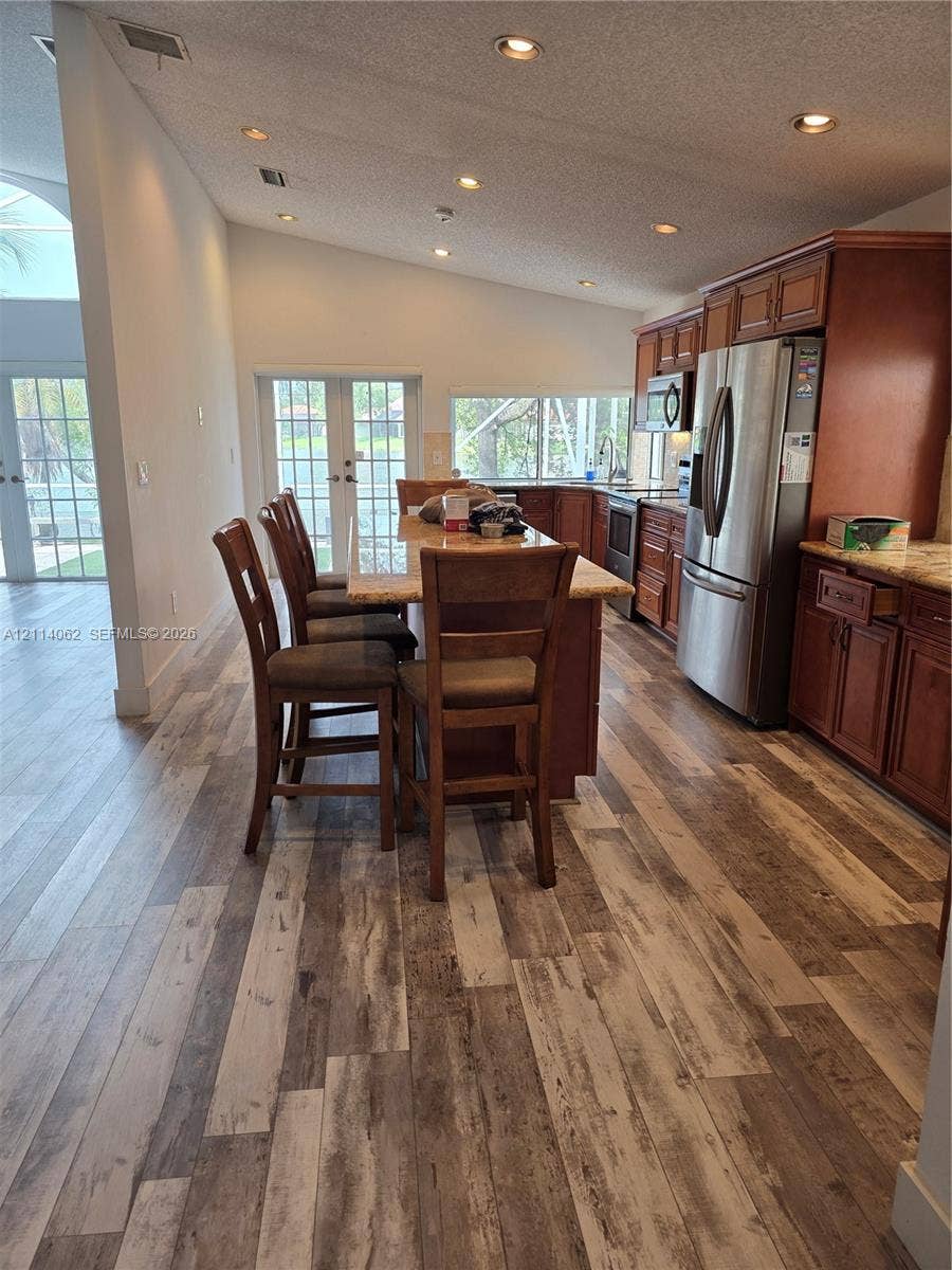 Weston, Weston, FL 33326 Kitchen featuring wood-finish flooring, recessed lighting, stained wood cabinetry, stone-finish countertops, and stainless steel appliances