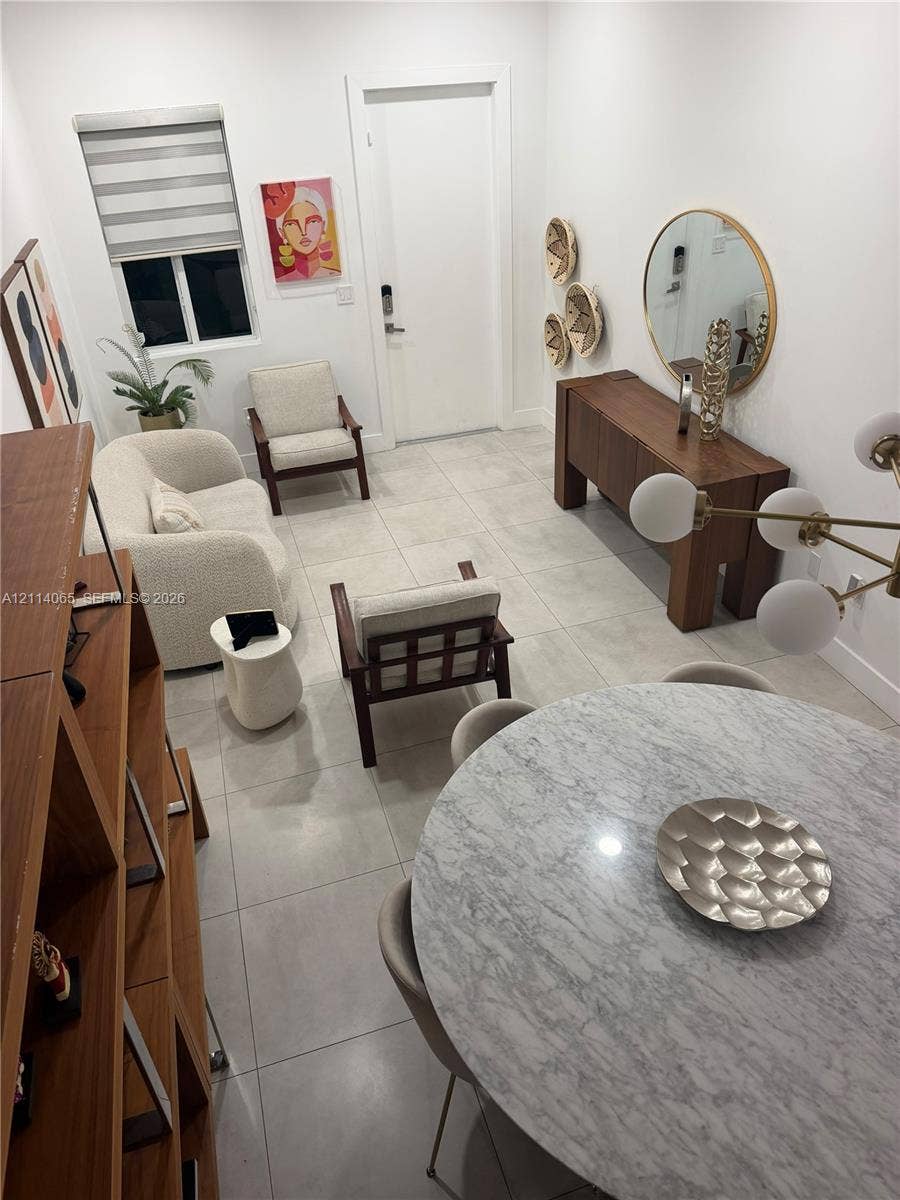 Large-format ceramic tile flooring, neutral walls, and a modern multi-globe chandelier