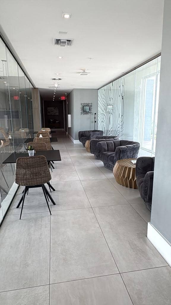 Large-format floor tiling, floor-to-ceiling glass wall partitions, and recessed ceiling lighting