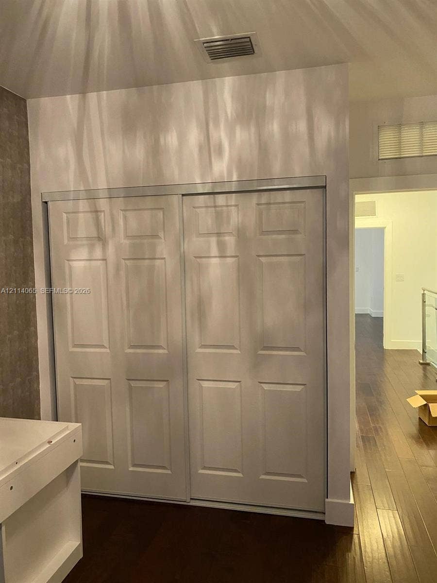 Six-panel sliding closet doors and wood-finish flooring