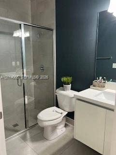 Glass-enclosed shower with tiled surround, white cabinet vanity with integrated sink, rectangular wall-mounted mirror, and neutral tile flooring