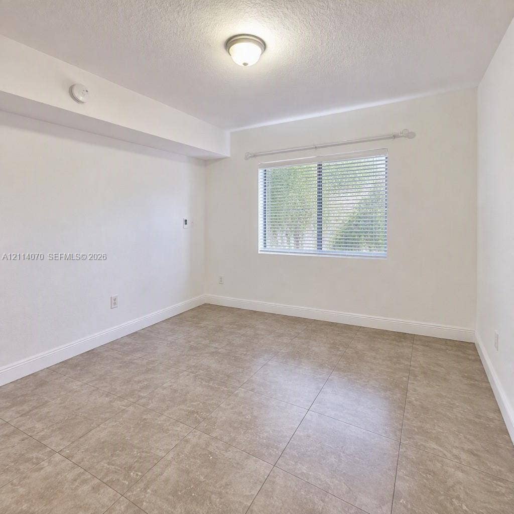 15400 SW 284th Street, #1204, Homestead, Homestead, FL 33033 Neutral-toned tiled flooring, wall-mounted light fixture, and window with adjustable blinds
